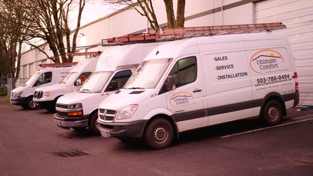 Service vans parked outside Ultimate Comfort HVAC company.
